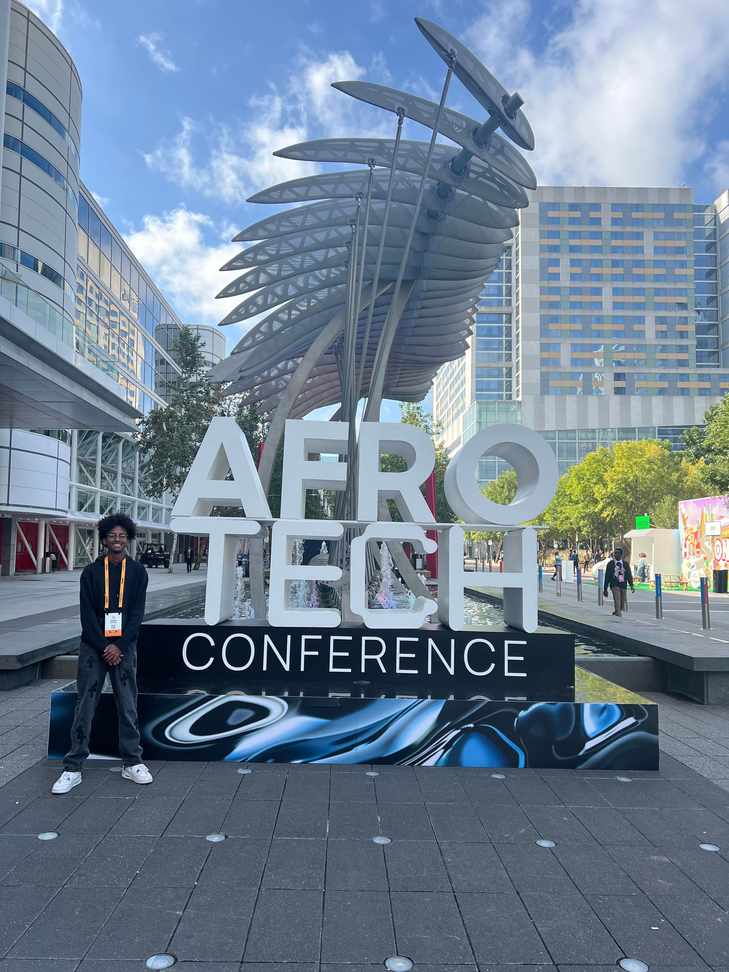 Adam standing in front of the AfroTech Conference sign in Houston